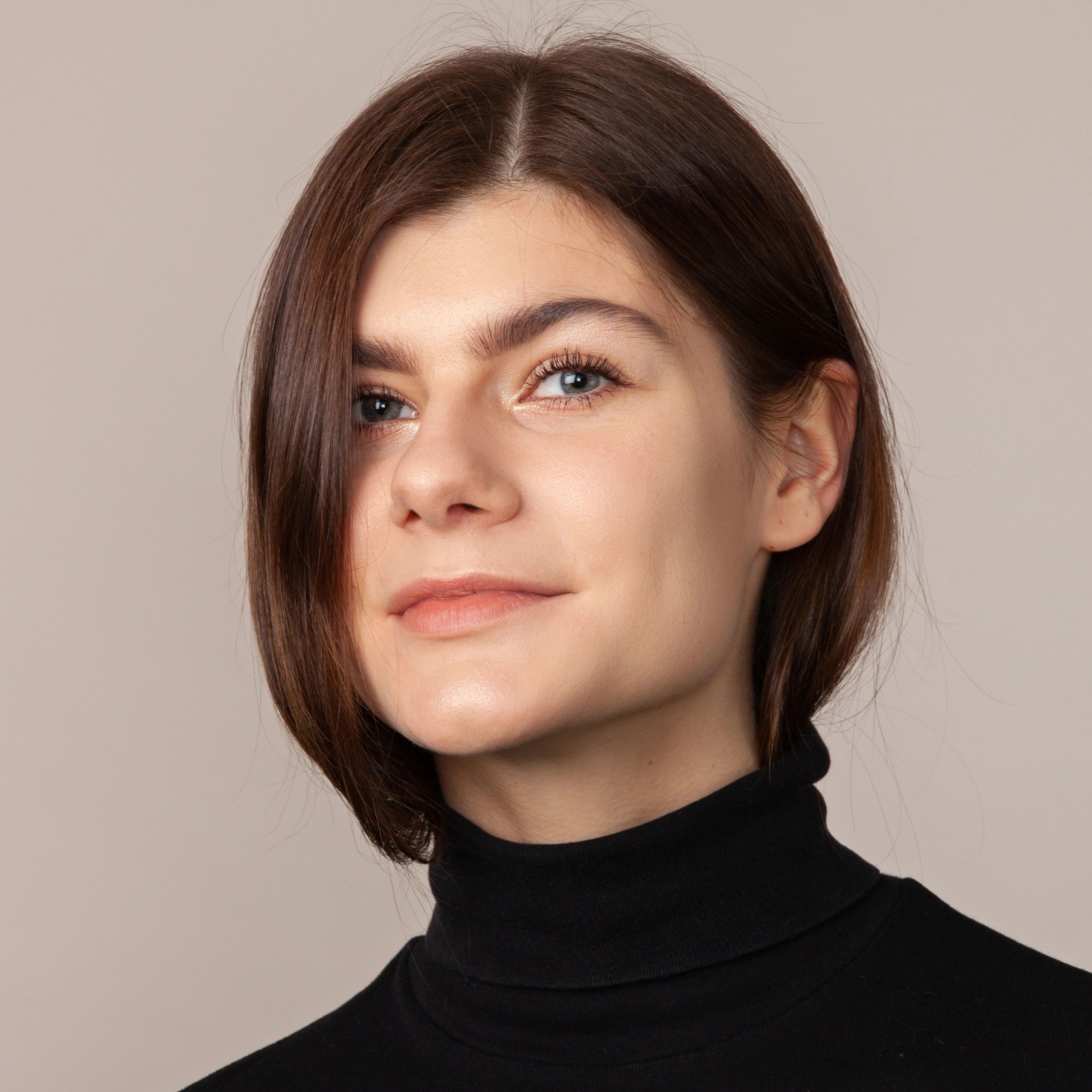 Portrait of a smiling young woman on a beige background