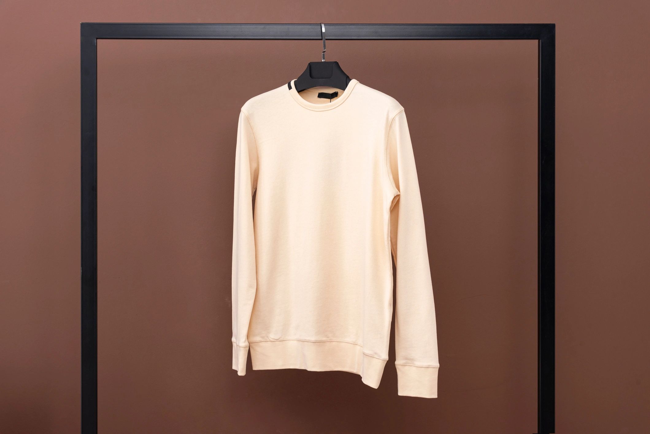 Minimal crewneck sweatshirt on a hanger, styled for a clean boutique look