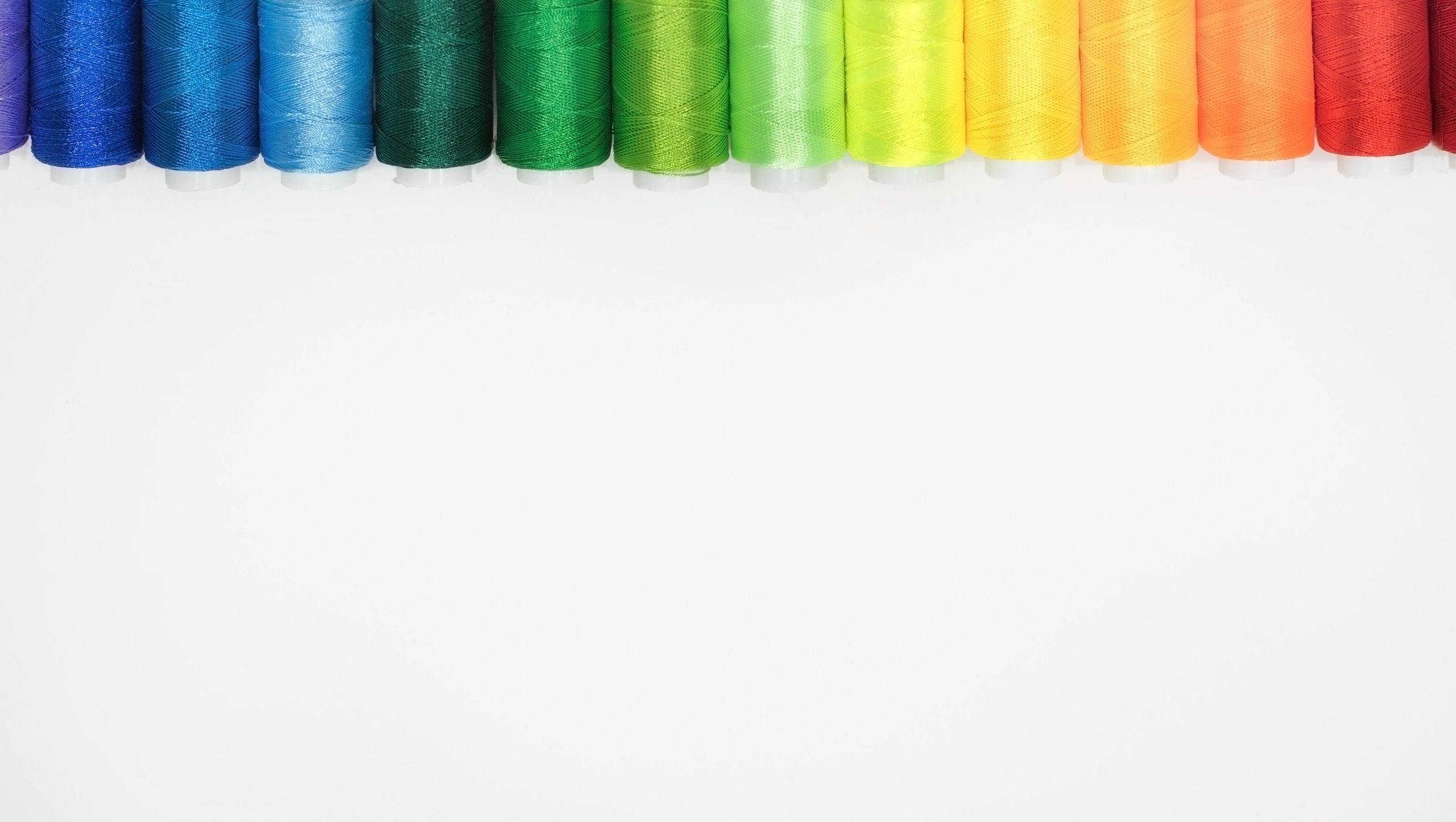 Colorful thread spools arranged in a flat lay