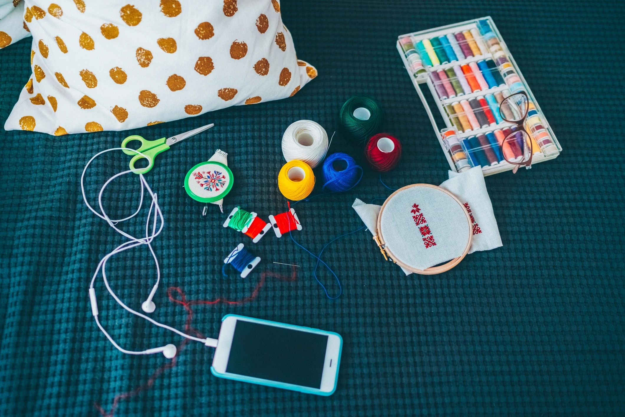 Embroidery supplies laid out with a smartphone nearby